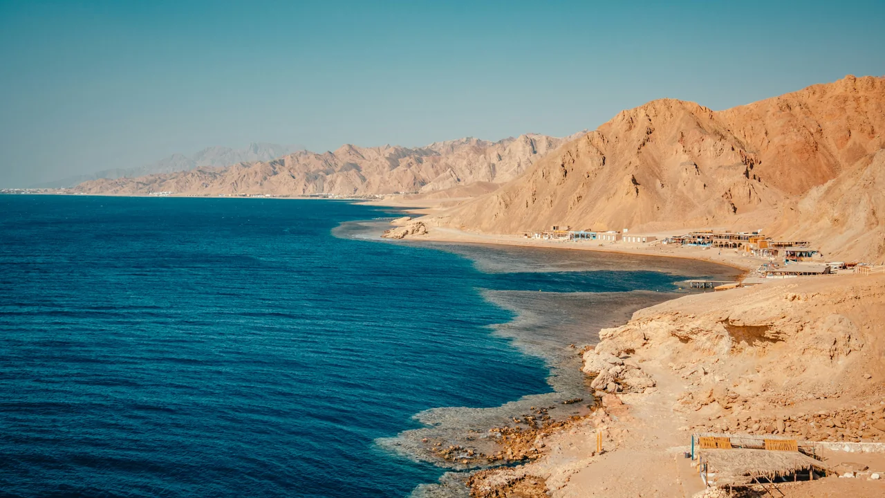 Küste bei Dahab mit tiefblauem Meer und braunen Bergen