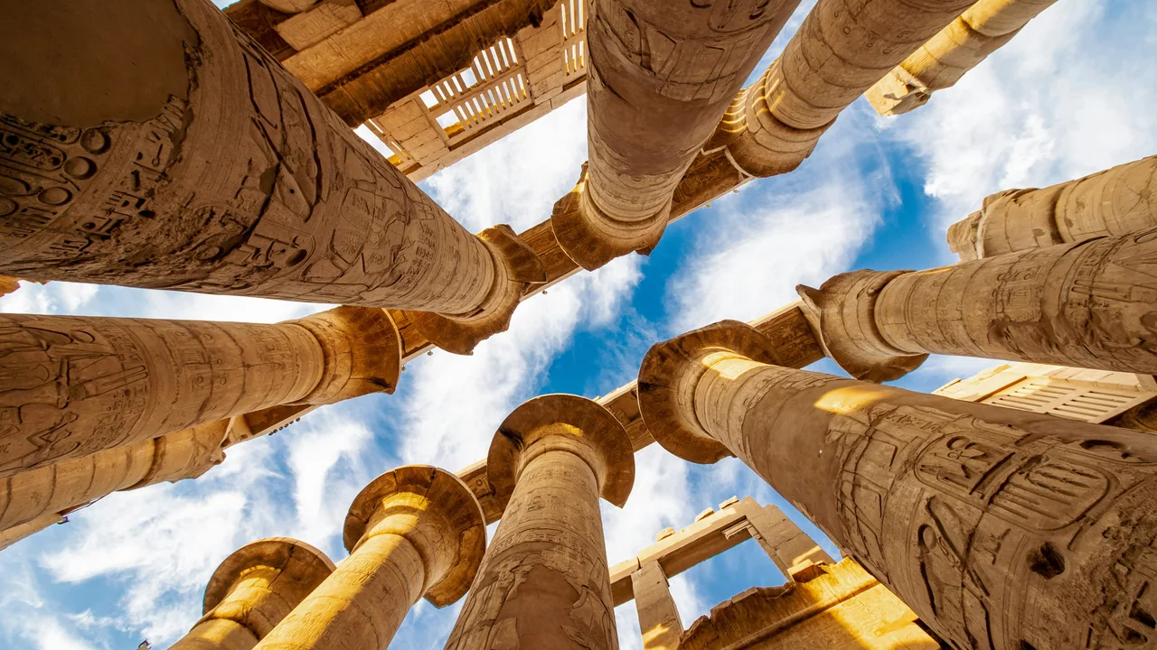 Blick nach oben zwischen Tempelsäulen mit Hieroglyphen in Luxor