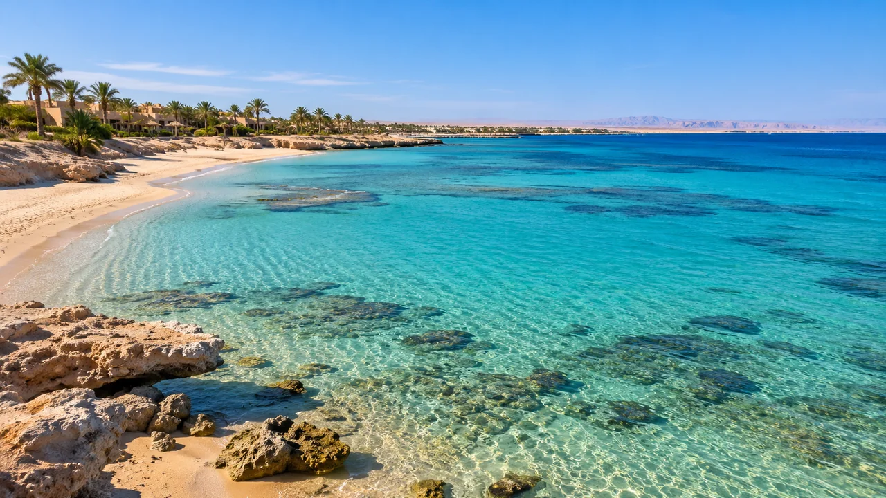 Heller Sandstrand mit Palmen und flachem türkisfarbenem Wasser am Roten Meer