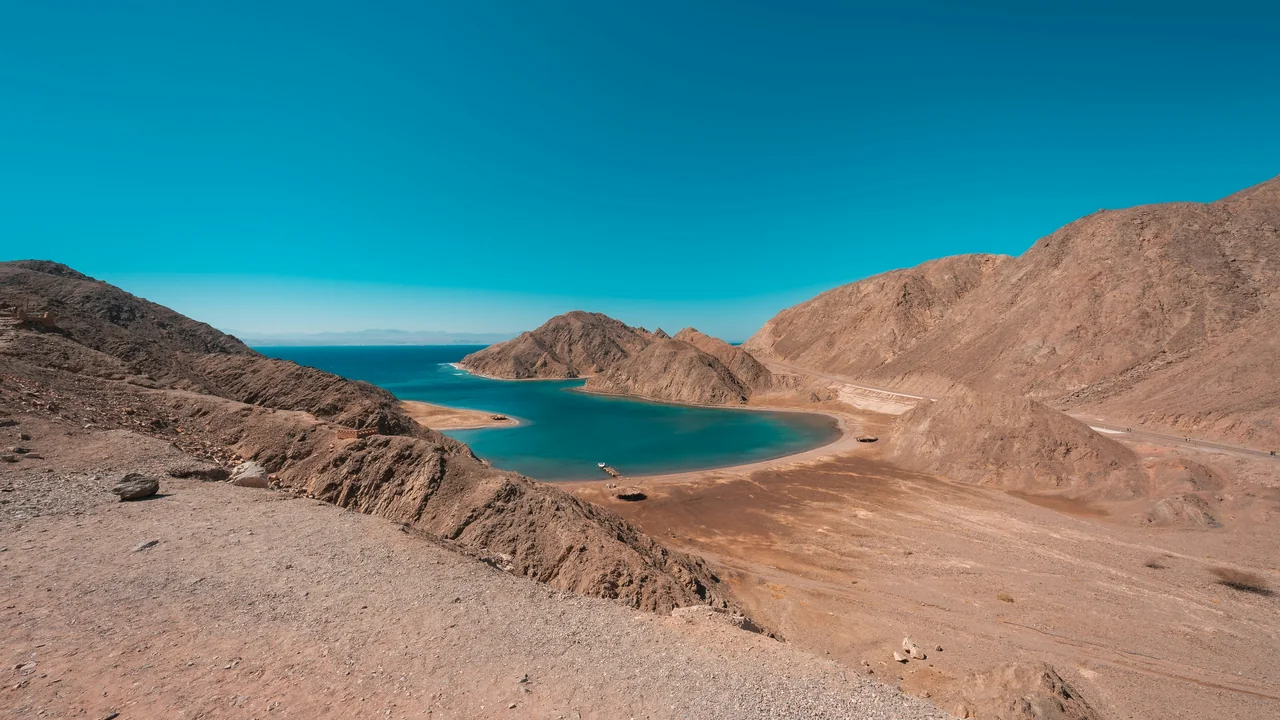 Bucht mit türkisfarbenem Wasser zwischen Wüstenbergen an der Sinai-Küste bei Nuweiba