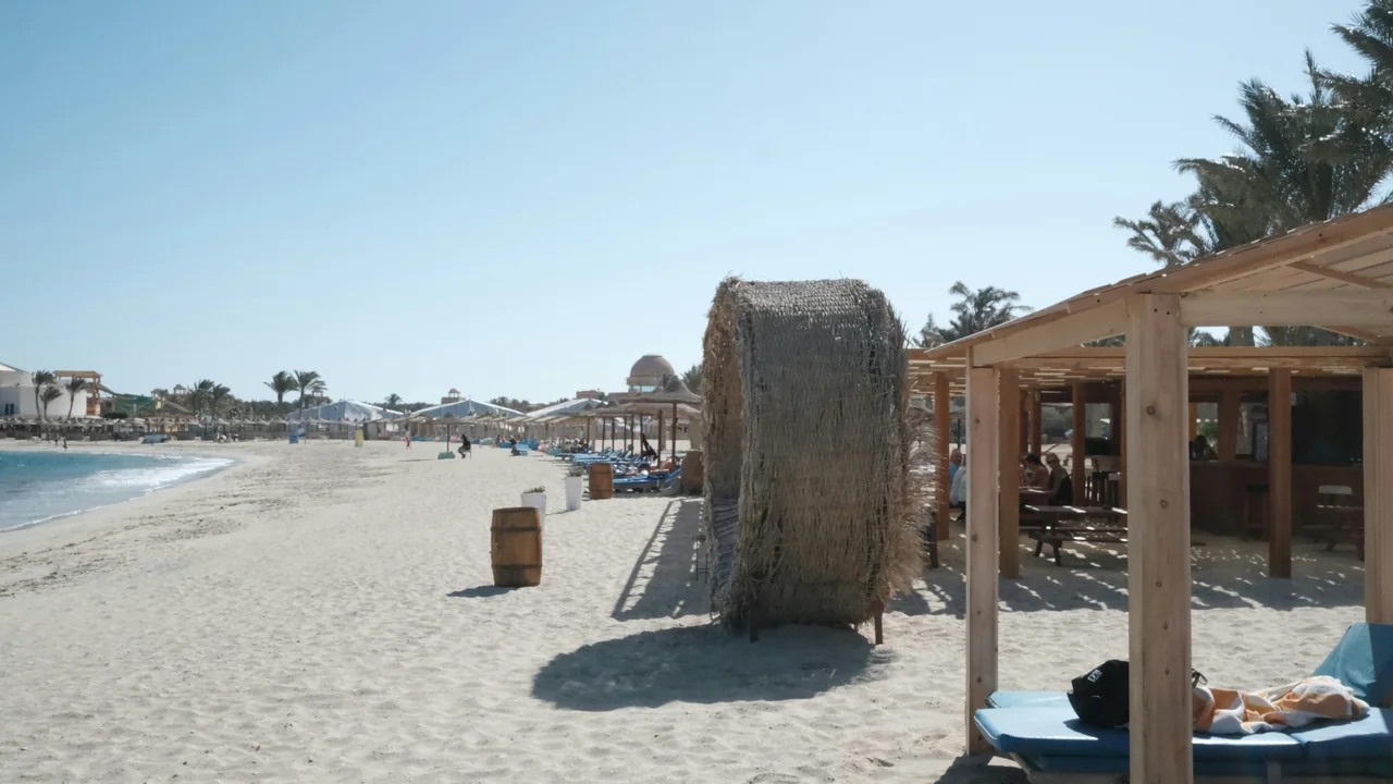 Sandstrand mit Liegen und Sonnenschirmen bei Marsa Alam