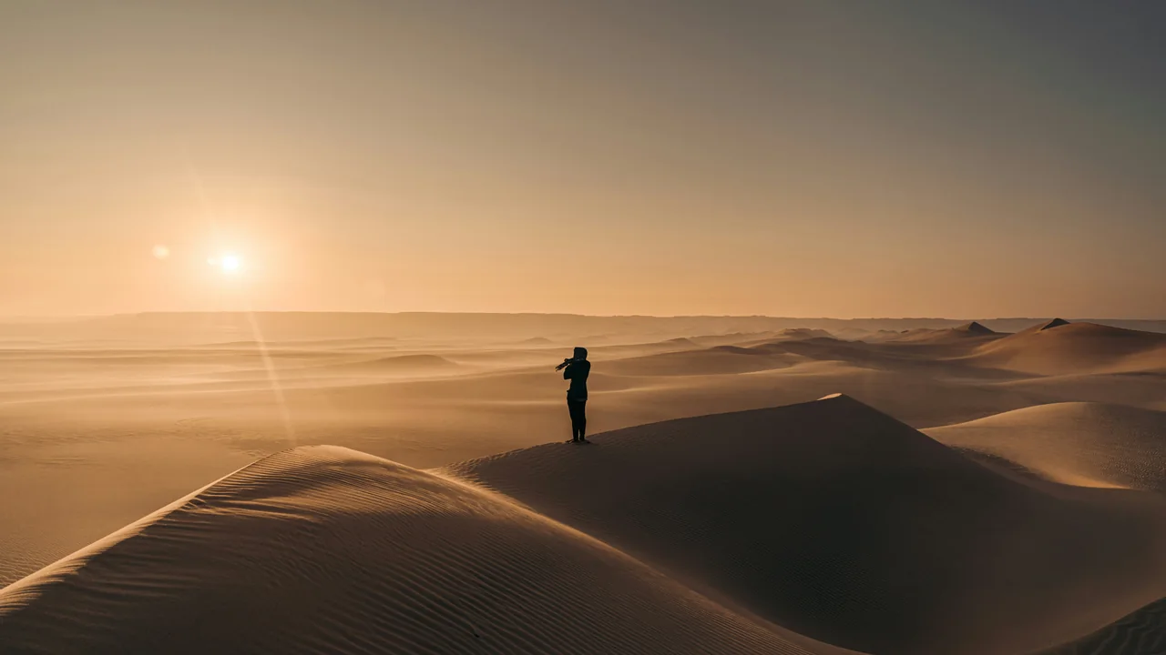 Person auf einer Sanddüne im Fayum bei Sonnenuntergang
